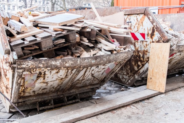 Abfallcontainer von einem Entsorgungsunternehmen ist mit Altholz befüllt